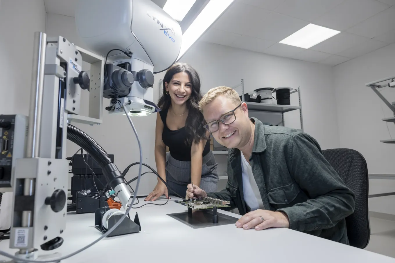 Axis colleagues Reem Chahrour Muhieddine and Jonas Lorander smiling during a collaborative session at a desk.