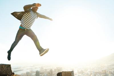 Man jumping with a city in the background