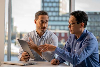 Two men discussing over tablet