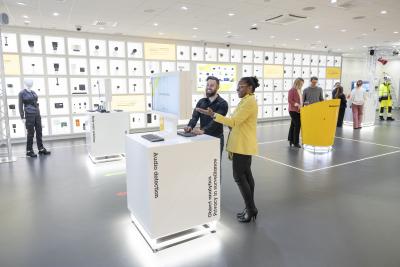 People exploring Axis products in an Experience Center. The wall is lined with Axis cameras and products.