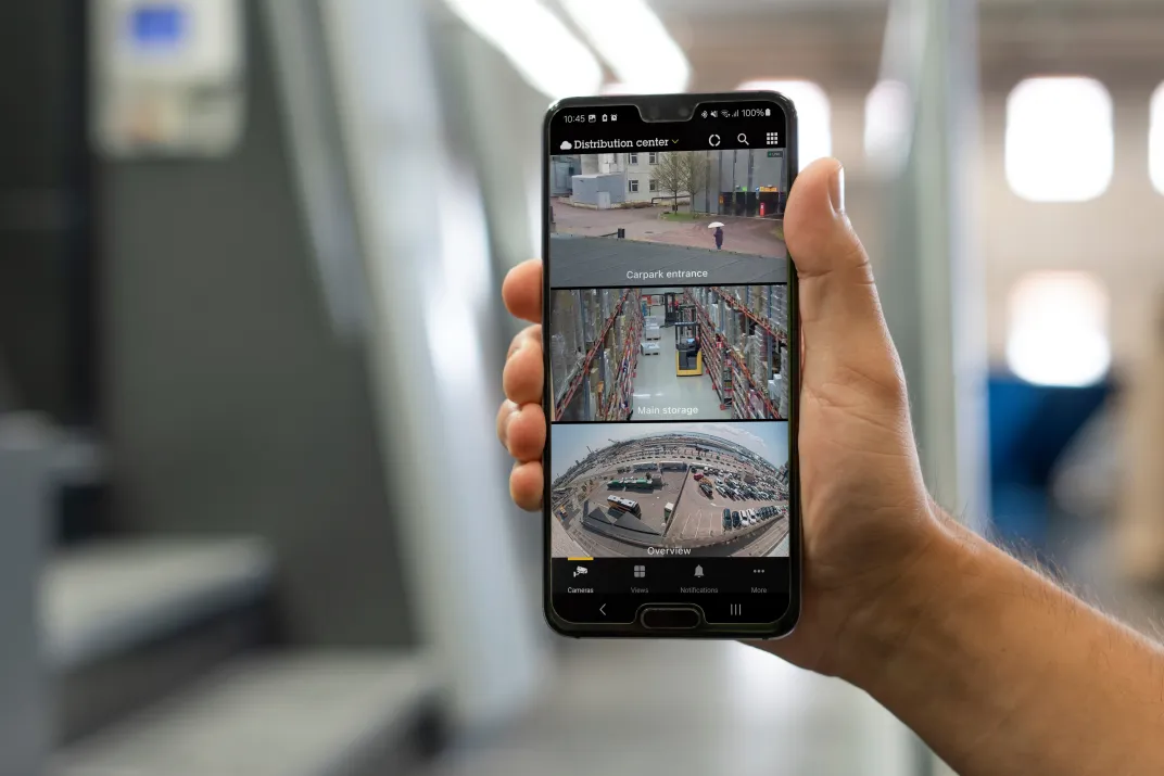 A phone held by a person to show AXIS Camera Station Pro's features all in one place.